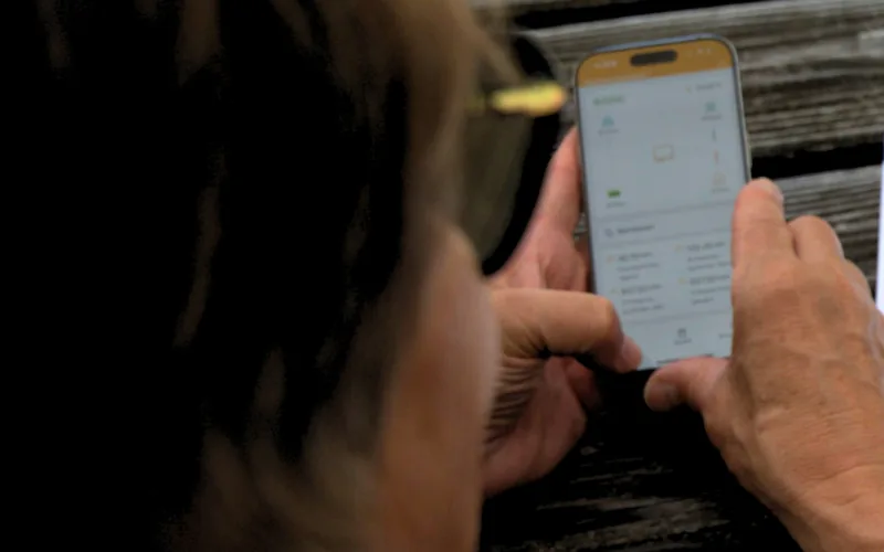 Kunde prüft in der Energiemanagement-App Erzeugung, Verbrauch und Speicherstand seiner Photovoltaikanlage