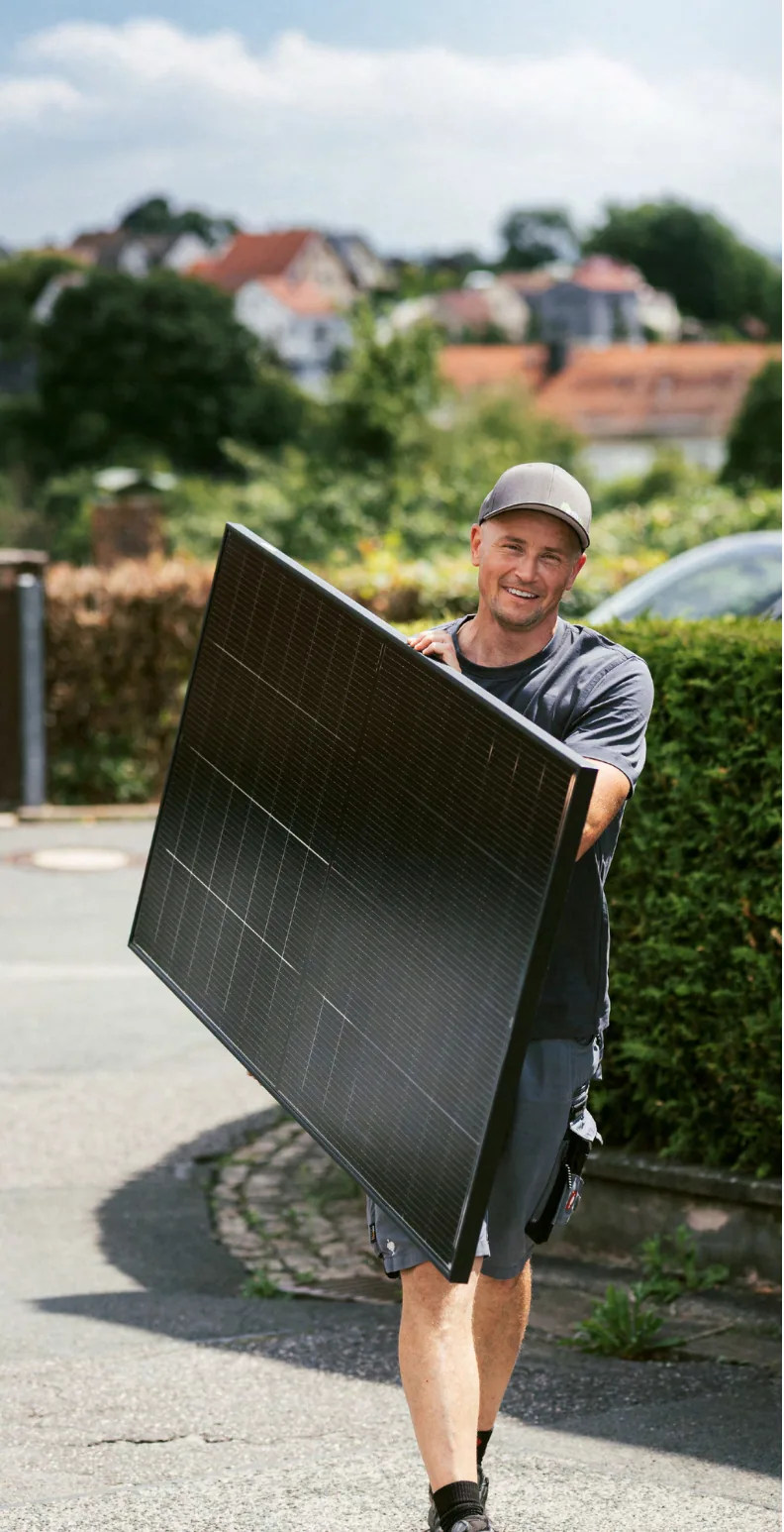 ehoch7 Monteur trägt ein Fullblack Doppelglas-Solarmodul