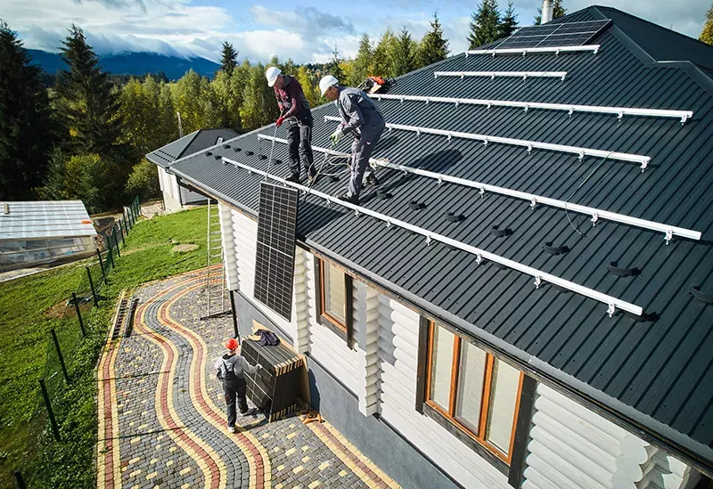 2 Männer auf dem Dach ziehen PV Module nach oben