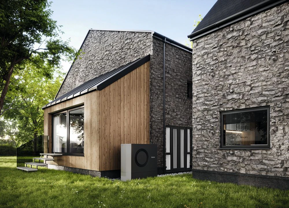 Haus mit Steinfassade und Außeneinheit Wärmepumpe (Buderus Motiv)